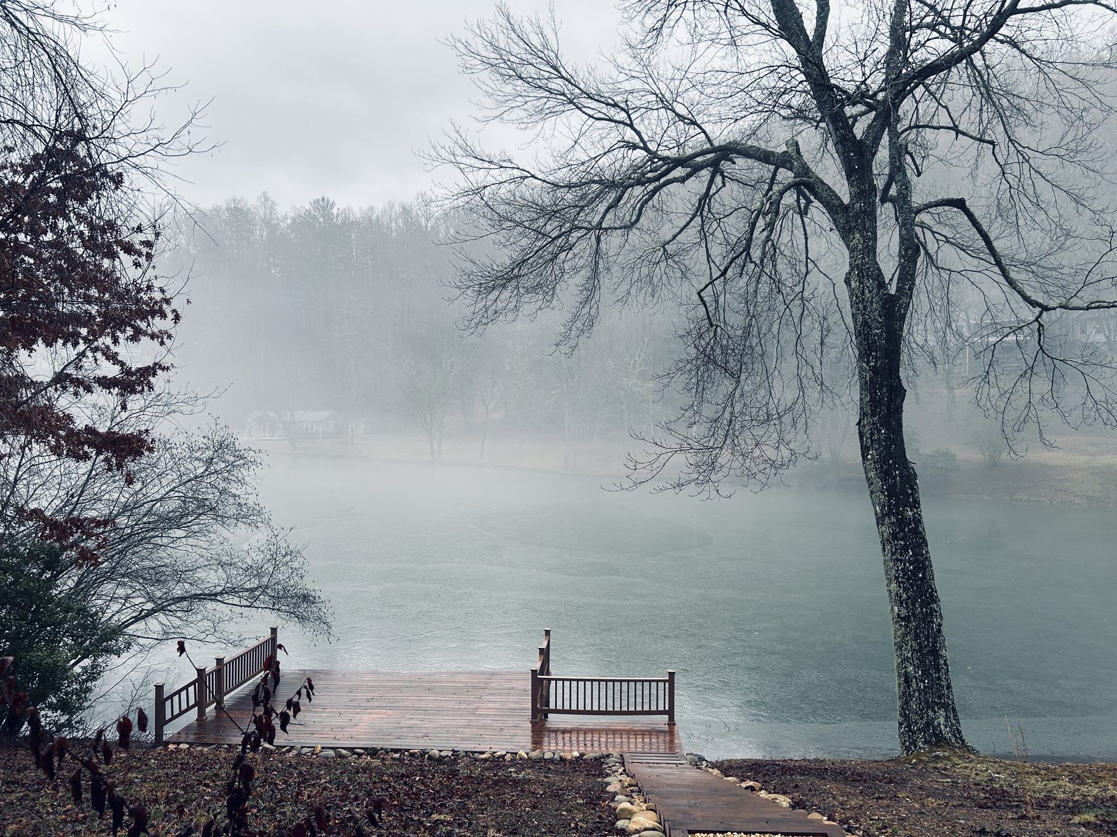 A misty dock on still water in winter
